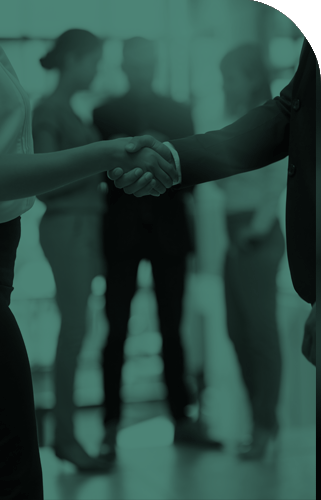 Man and Women shaking hands with a group of IT people in the background