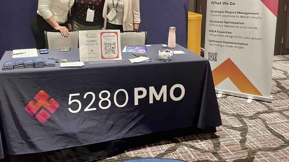5280 PMO team at event booth featuring branded collateral designed by 4B Marketing for marketing 5280 PMO